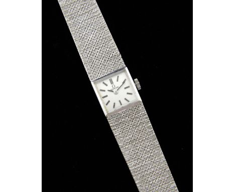 Omega, ladies 9ct white gold bracelet watch, square silver dial with an integral textured bracelet signed Omega 9ct. Manual w