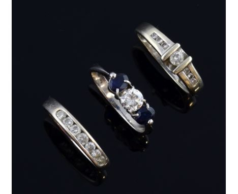 Three modern white gold rings, a three stone ring with diamond and two sapphires, stamped 750 for 18 ct gold, channel set dia