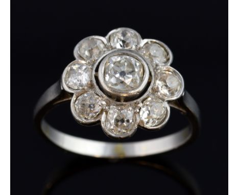 Edwardian diamond flower head ring, central  old cut stone, in rubover setting estimated at  0.50 carat  and eight stones of 