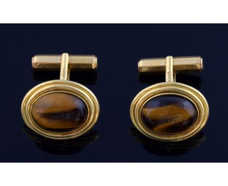 A pair of vintage cufflinks set with oval cabochon tigers eye stones in 18 ct gold  21.6 grams gross 