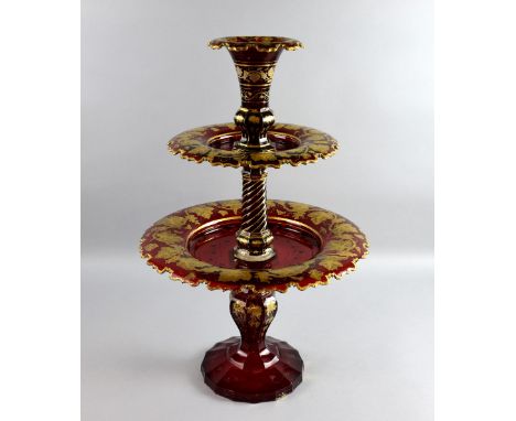 Bohemian ruby glass two tier table centrepiece with a trumpet vase surmount on shaped base with gilt grapevine decoration, 63