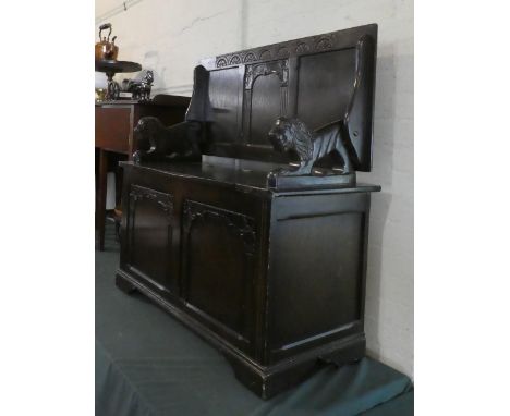 A Mid 20th Century Oak Monks Bench with Carved Hinged Lid, Panelled Base and Carved Lion Armrests, 95cm Wide 