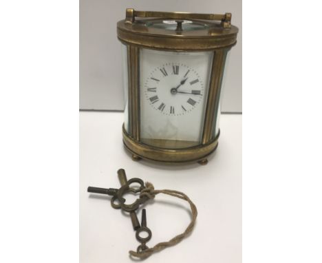 A circa 1900 French lacquered brass cased carriage clock of oval form, the movement with repeat and white enamel dial with Ro
