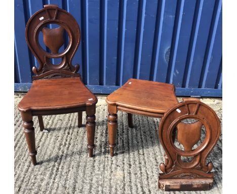 A pair of Victorian mahogany panel seat hall chairs with shield-shaped medallion decorated backs, on turned and ringed taperi