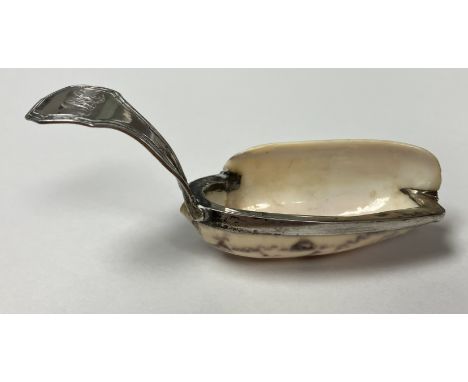 A late Georgian white metal mounted shell caddy spoon, the curved handle with reeded decoration, initialed "MC", approx 7.5 c