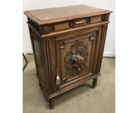 A circa 1900 French oak confiturier or preserves cupboard, the plain top over a moulded decorated frieze and fruit and foliat