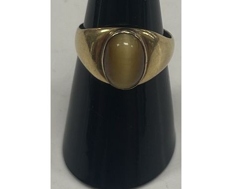 An 18-carat gold oval cabochon tiger's eye mounted dress ring, 7 g, size N/O