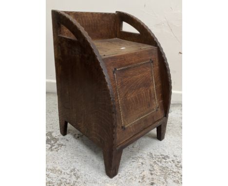 A Cotswold School Arts & Crafts quarter cut oak coal box of curved outline with notch carved decoration to the edges, the bar
