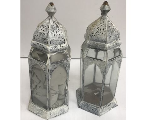 A collection of painted metal hanging lanterns of various forms, together with two brass and green and clear glass wall lante