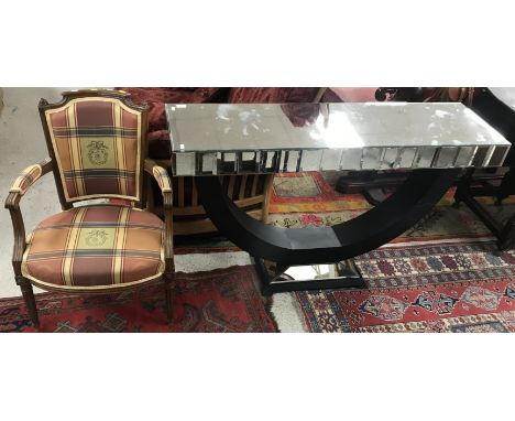 A modern mirrored console table, the plain top above a bevelled panelled frieze, on an ebonised U-shaped support to a canted 