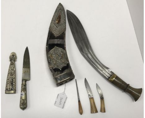 A vintage Gurkha kukri with typical curved steel blade and carved horn handle housed in a white metal mounted velvet covered 