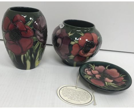 A Moorcroft "Tribute to Anemone" baluster shaped vase on a green ground, bearing impressed marks and price tag "£395", 11 cm 