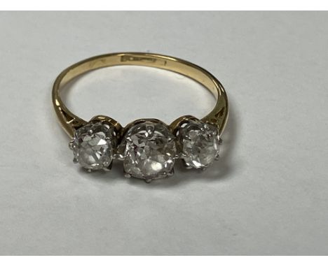A gold set three stone diamond ring (marks worn, carat unknown), the centre stone approx. 0.5 carat, flanked by two smaller s
