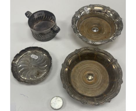 A white metal two handled cylindrical bowl with wrythen decoration, bearing ownership initials "E*H*N*M" and with half skull 
