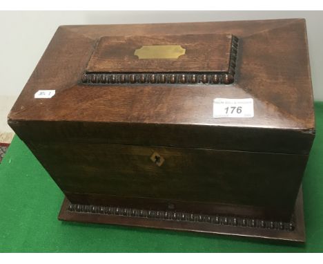 A 19th Century mahogany tea caddy of sarcophagus form, the top opening to reveal two canisters and a bowl recess, over a sing