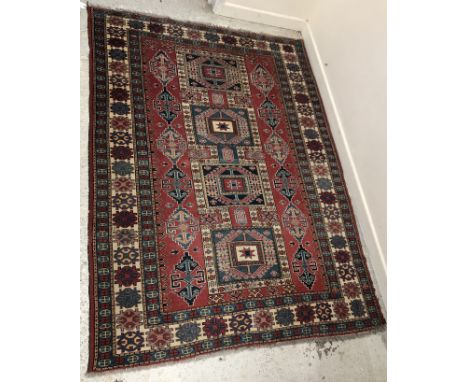 A Qashqai rug, the central panel set with four repeating joined medallions on a red and blue ground, within a stepped blue, c