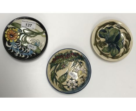 A collection of three Moorcroft pin dishes to include one "Lily Plume" pattern by Emma Bossons, dated "2007", No'd. "683" to 