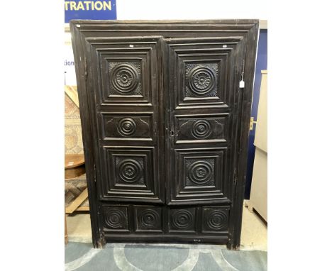 An 18th Century Breton French chestnut armoire or cupboard, the two doors with carved fielded medallion decoration over a fri