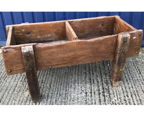 A 19th Century rustic elm two section trough, each side with draining plugs, raised on heavy bolted square supports, 137 cm w