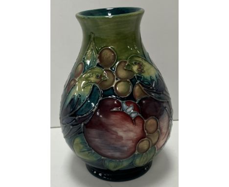 A Moorcroft "finches and fruit" pattern blue green ground baluster shaped vase on a circular foot, 13.5 cm high