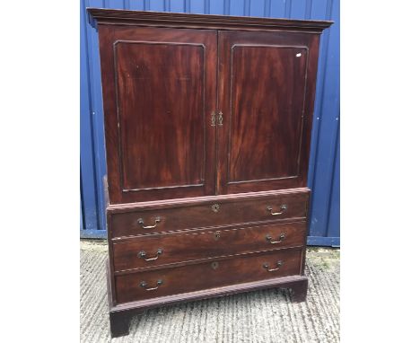 A 19th Century mahogany linen press, the moulded cornice over two panelled cupboard doors enclosing a hanging space with two 