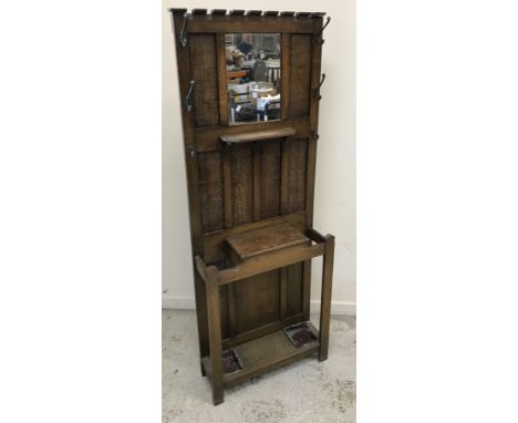 A canework dog bed, strapwork decorated trunk and three various suitcases and an early 20th Century oak hall stand