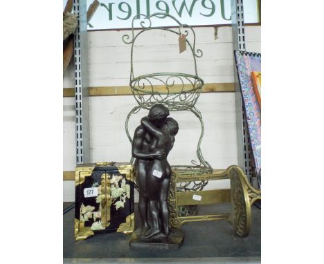 A two tier metal flower basket, a naked man and woman embracing, a small cabinet with oriental decoration and a small glass h