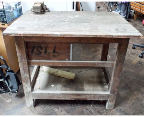 A small engineers work bench with vice and one drawer and under shelf