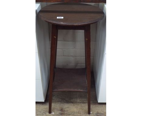 A round walnut plant stand with shelf below