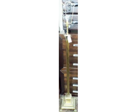 A heavy brass Corinthian column standard lamp standing on paw feet 
