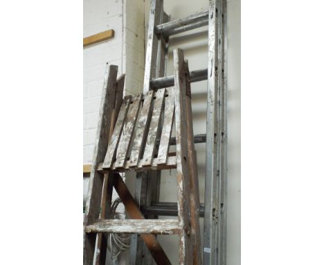 A tall pair of wooden step ladders and a small extending aluminium ladder of nine rungs
