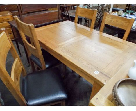 A good quality heavy light oak dining room suite comprising extending table with fold away leaf, four ladder back chairs with