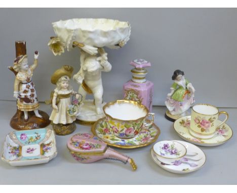 A collection of porcelain figures and china cups, saucers, trinket trays, scent bottle and a cherub centre piece