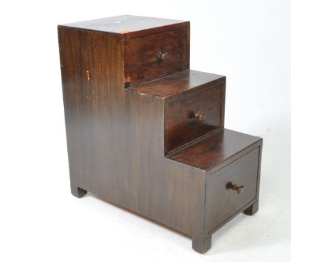 A vintage 1940s Art Deco mahogany graduating set of drawers in library step form. Raised on square block feet with turned squ