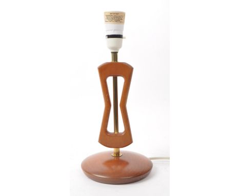 British Modern Design - A mid 20th century teak table lamp. The lamp having abstracted forms to shaft with brass fixture over