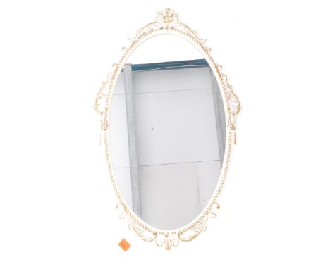 A vintage 20th century style Louis XVI wall hanging mirror. The mirror of oval form with scrolled acanthus decoration to fram
