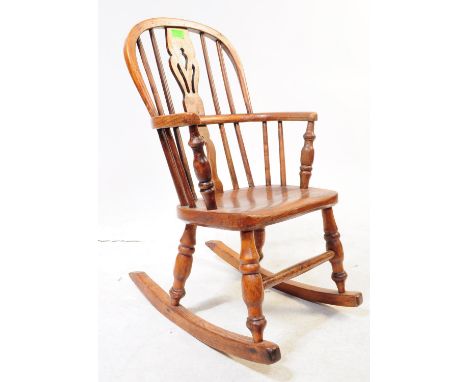 A 19th century Victorian elm child's Windsor rocking chair. The chair raised on rocking sleigh runner feet under turned legs 