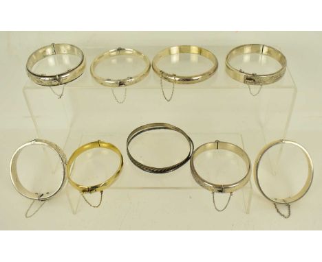 Nine hallmarked silver hinged bracelets with various decoration, width of widest 1.4cm, including one gold-plated example wit