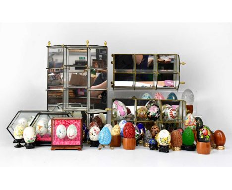 A collection of glass, ceramic, enamelled and painted eggs, together with three decorative stands (2).