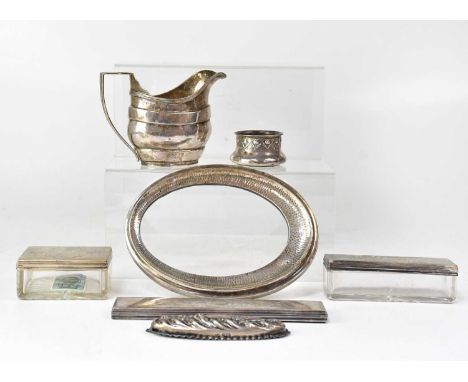 A hallmarked silver milk jug, Chester 1904, two Victorian silver lidded dressing table pots, three lids and the cover from a 