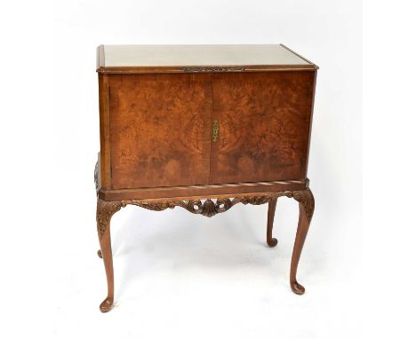 A mid-20th century walnut drinks cabinet with pair of cupboard doors and fitted interior, on carved cabriole legs, 110 x 93 x