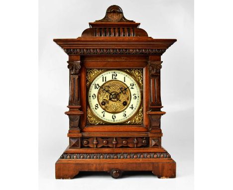 An Edwardian walnut eight-day mantel clock with twin drum movement striking on a gong, with 6.5" brass dial, the white enamel