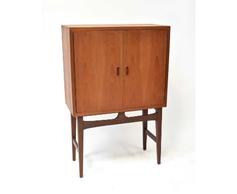 A mid-20th century teak G-Plan style cocktail cabinet with a pair of panelled doors, the interior with three-division upper s