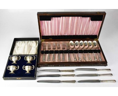 A cased set of four silver-plated open salts, three with blue glass liners, together with mixed flatware within a wooden box 
