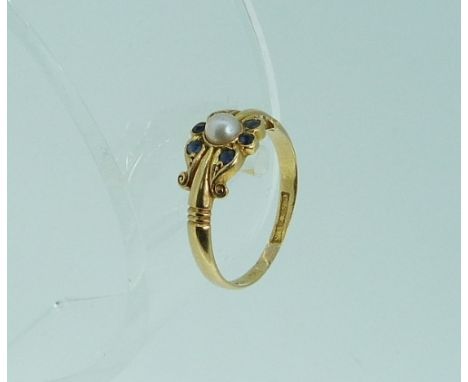 An 18ct yellow gold Dress Ring, the front set with a cultrured pearl with three small sapphire above and below, Size N.