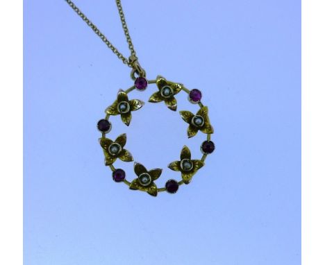 A 9ct yellow gold Pendant, the open circular pendant alternate set with flowers with seed pearl centres and small rubies betw