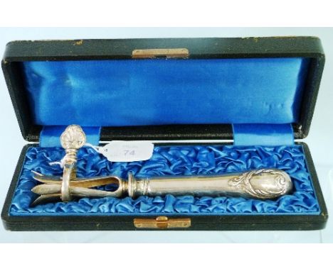 An early 20thC cased silver plated Meat Clamp, for holding lamb or chicken legs, the plain handle terminating with a scrollin