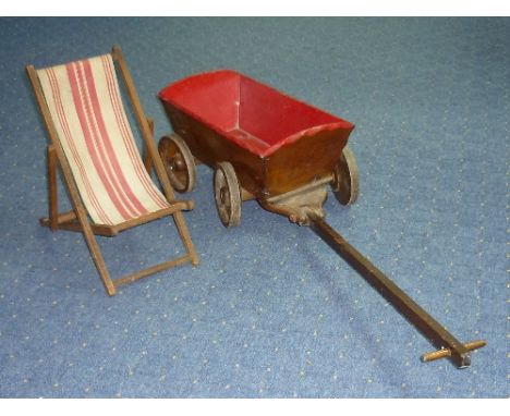 An early 20thC child's pull along four wheel Cart, with red painted interior and wooden handle, together with a vintage doll'