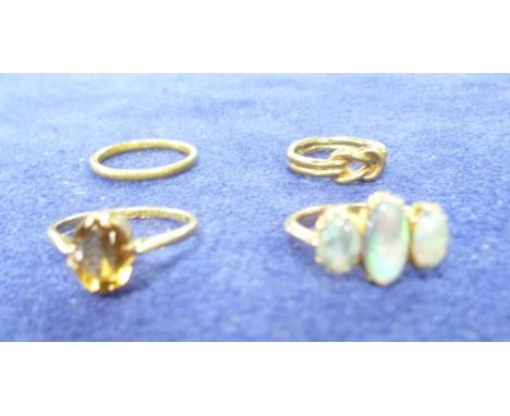 A collection of four rings, including a 22ct wedding band, 2.3g, a three stone opal ring, a 22ct set facetted topaz, a small 