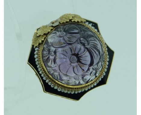 A large Dress Ring, formed of a foliate carved amethyst, with seed pearl surround, and black enamel shaped background, on a y